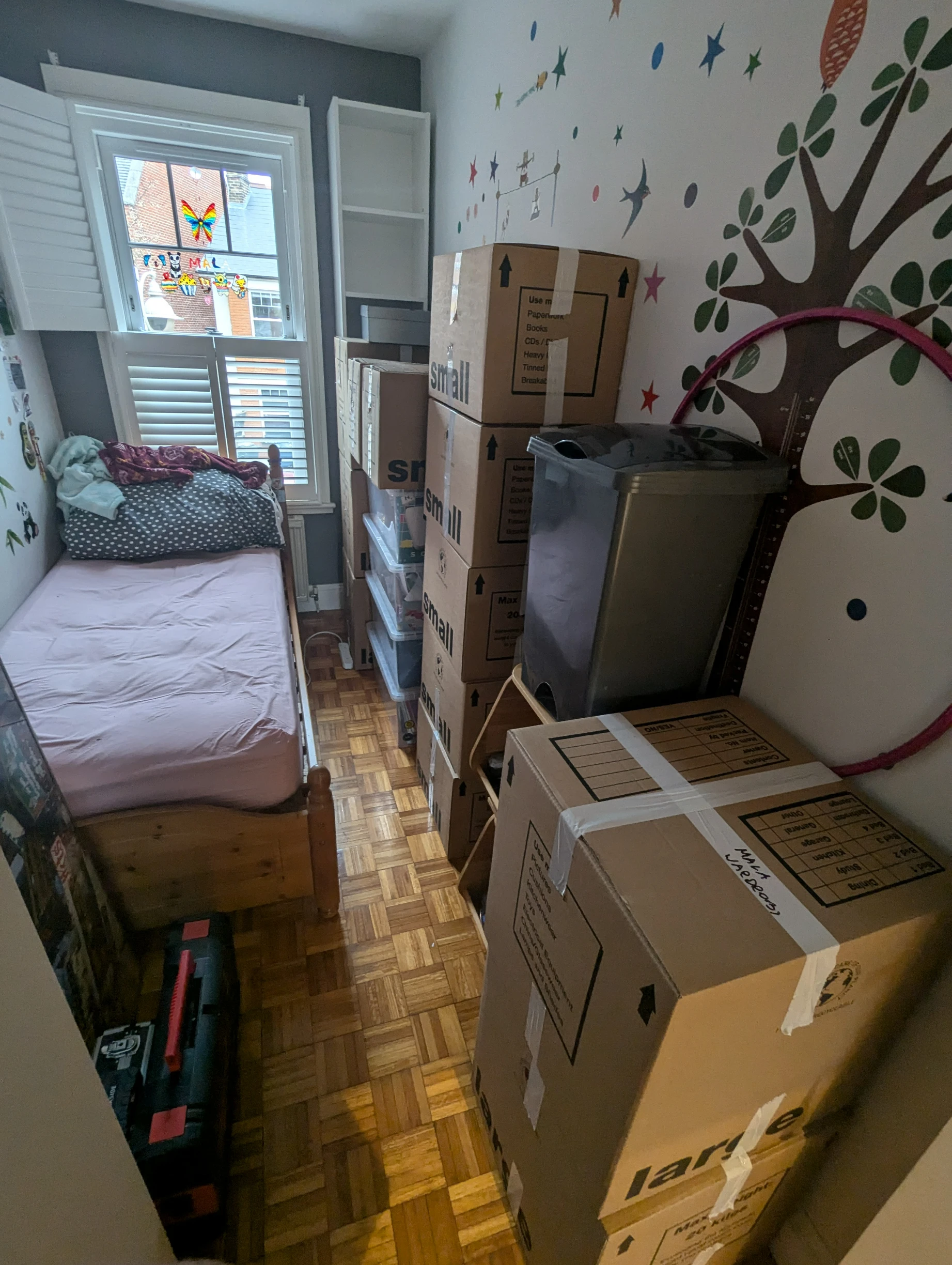 Perfectly packed and stacked boxes with custom cardboard packaging in a child’s bedroom, showcasing Rad’s moving packaging expertise in West London.
