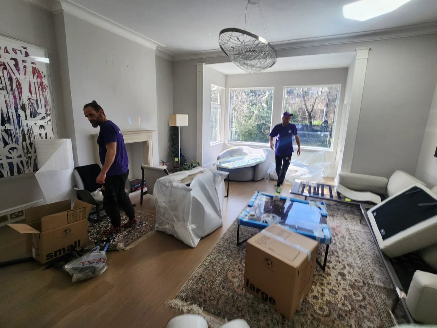 Rad’s team wrapping artwork and package artwork for storage in a West London living room, performing antique removal and antique furniture removal with precision.
