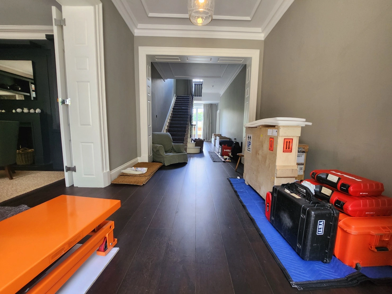 A corridor filled with various items, including freight-packed furniture and tools, organized for storage by RAD Removals and Storage during a home renovation.