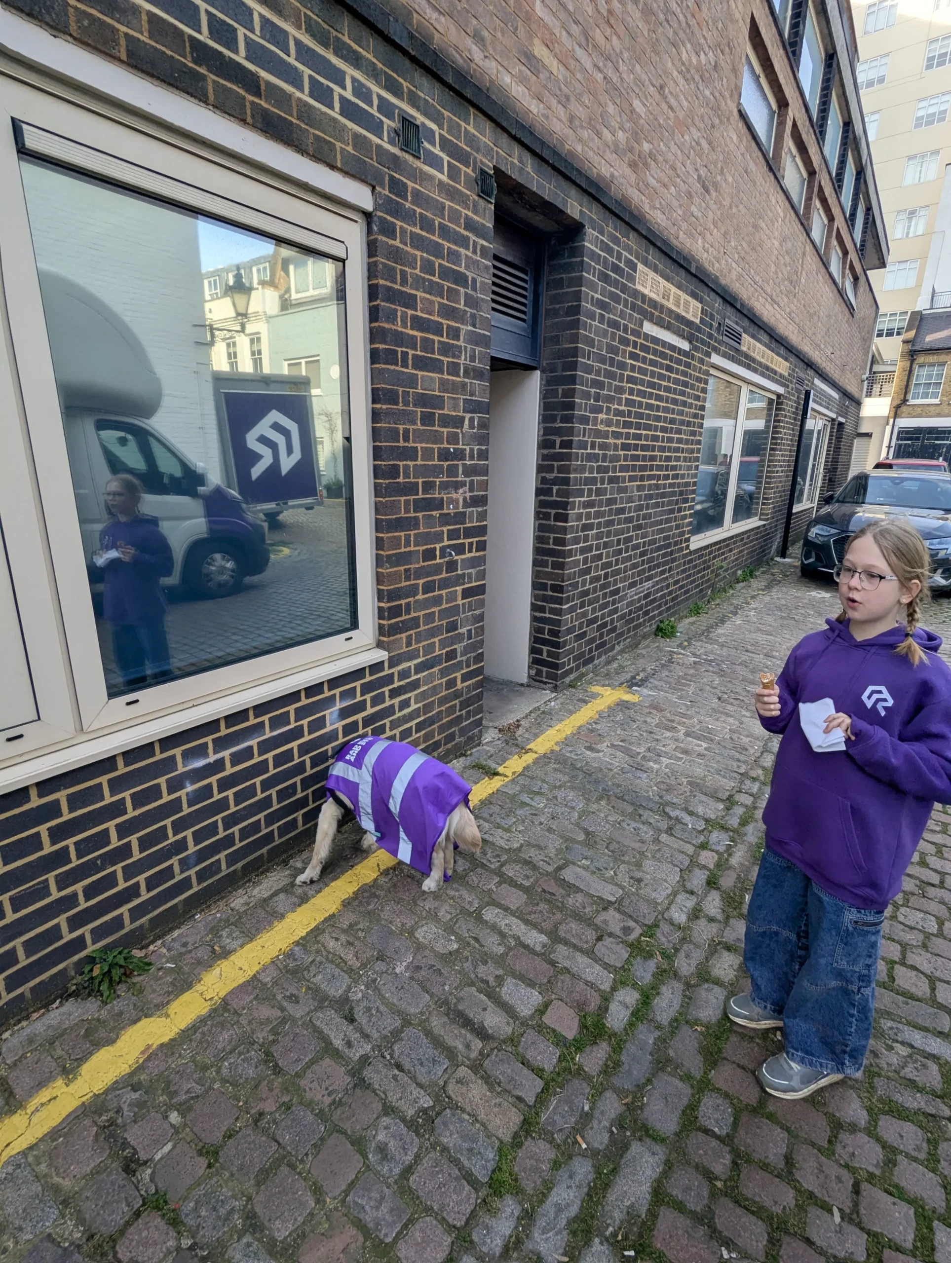Young person with a dog playing near a Rad Removals van in West London, showcasing student & short-term storage services.